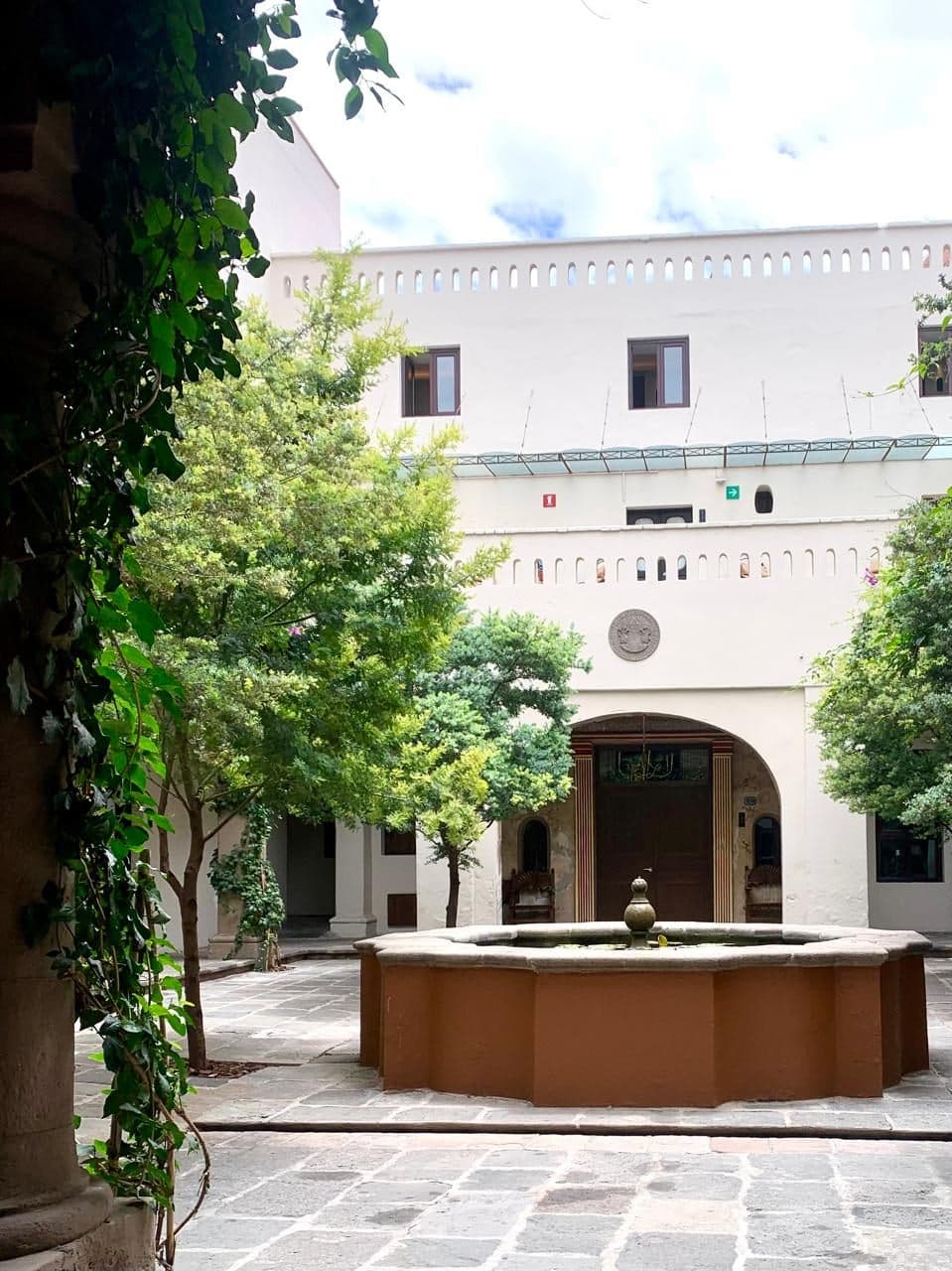 El patio blanco con su fuente, entre las enredaderas