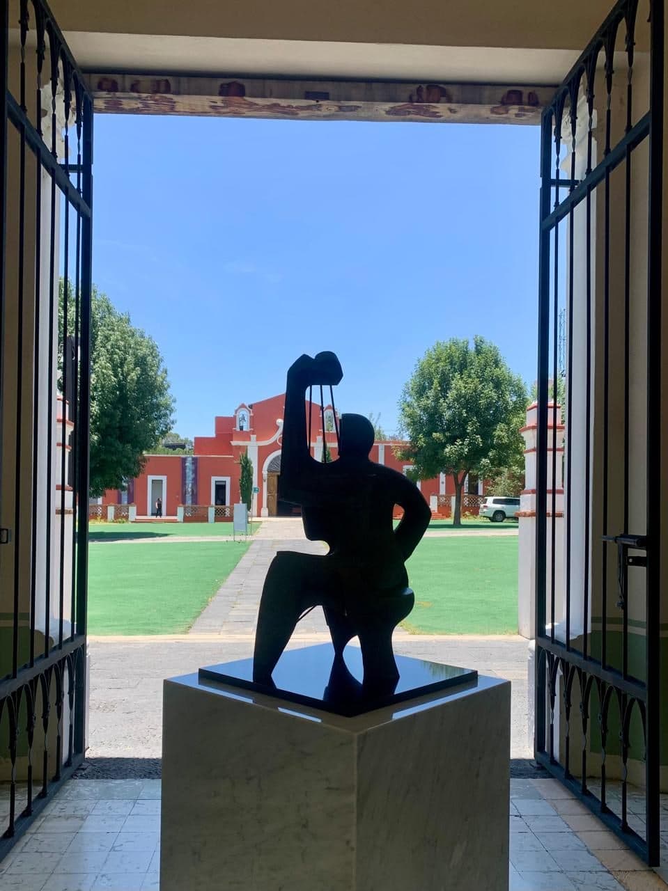 La escultura enmarcada por la puerta abierta