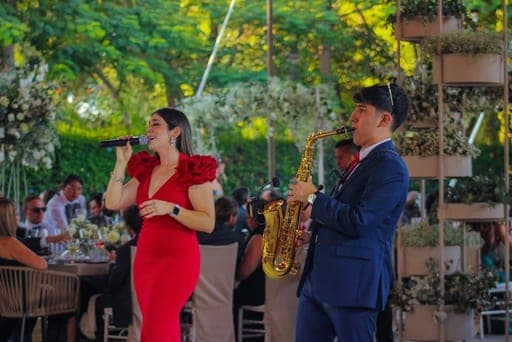 Tere cantando junto al saxofón, en una recepción al aire libre