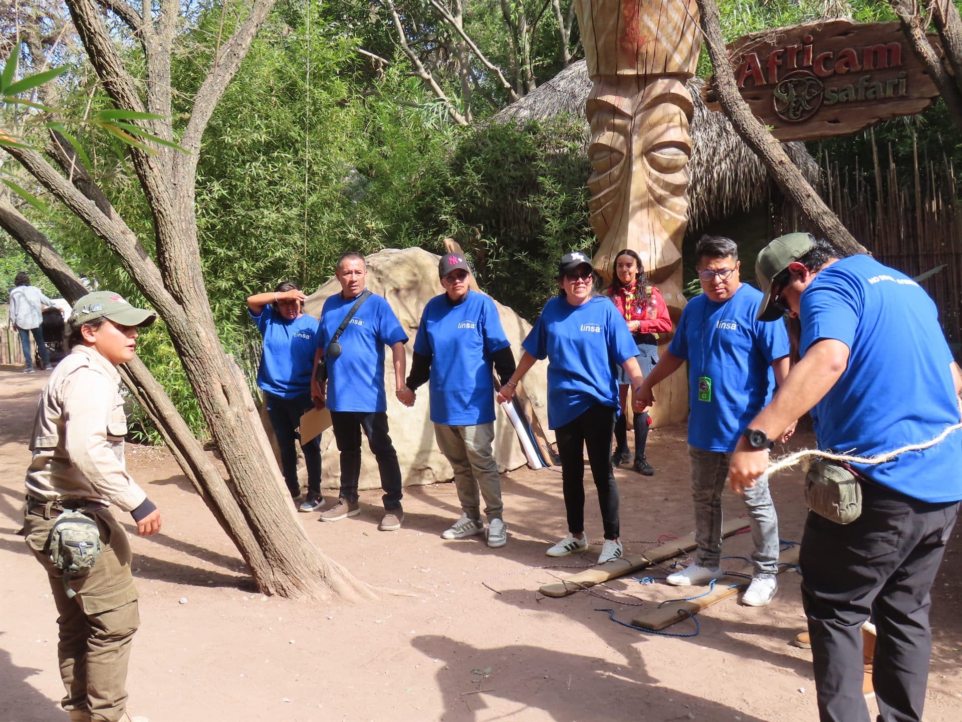 El equipo en el portón tallado de la Zona de Aventuras, con su scout