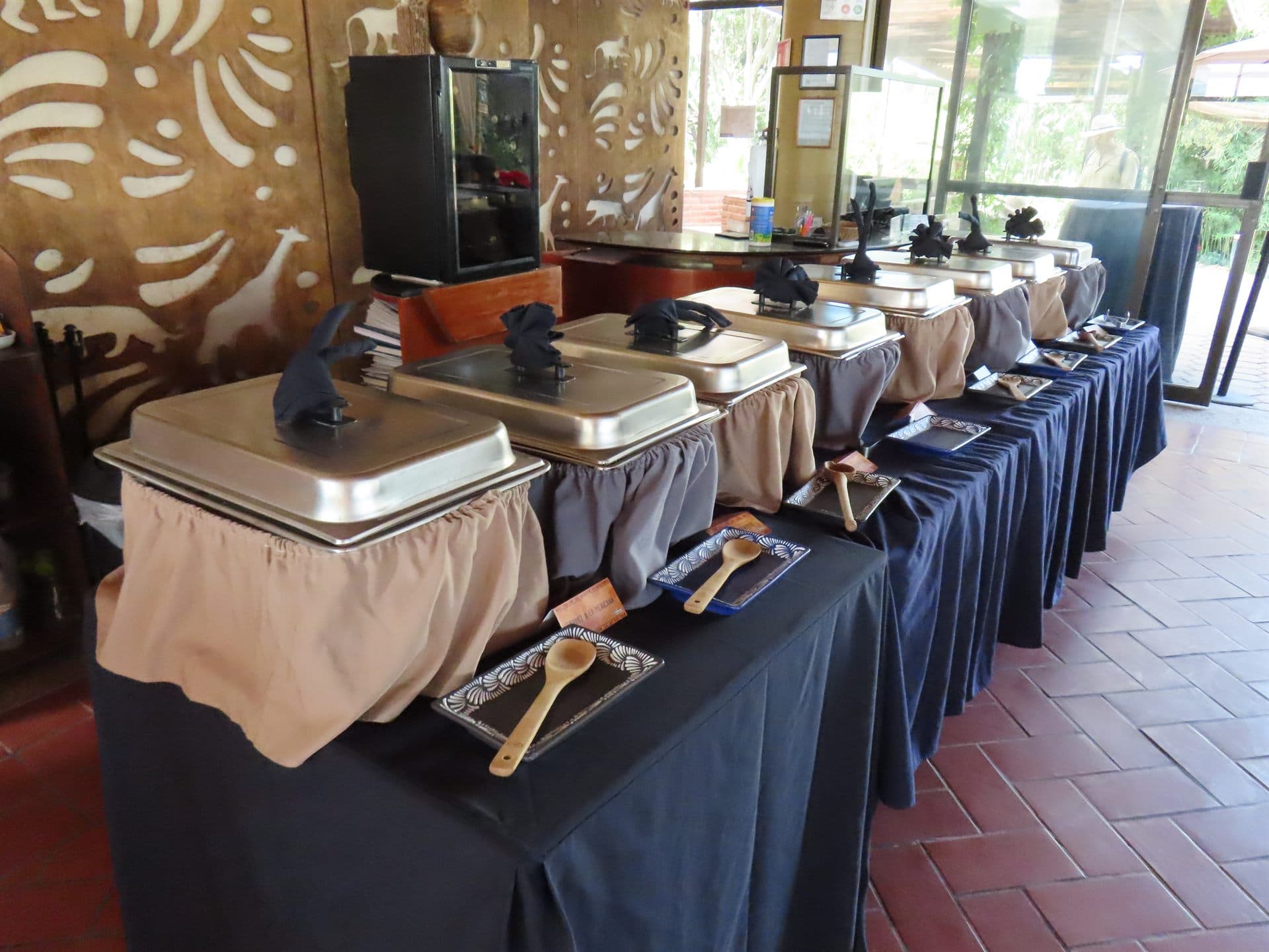 El buffet montado, con las charolas calientes sobre el mantel