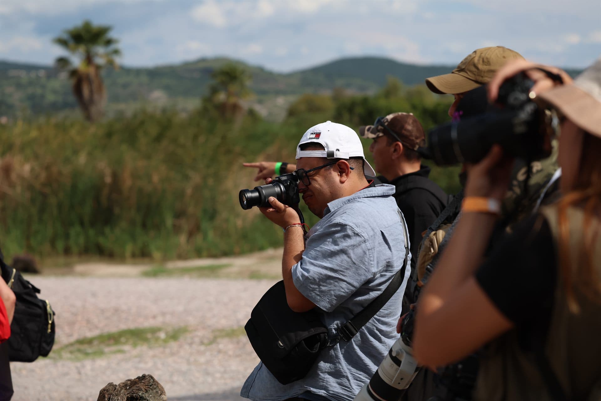 Dos participantes fotografiando entre las palmas y las lomas del parque