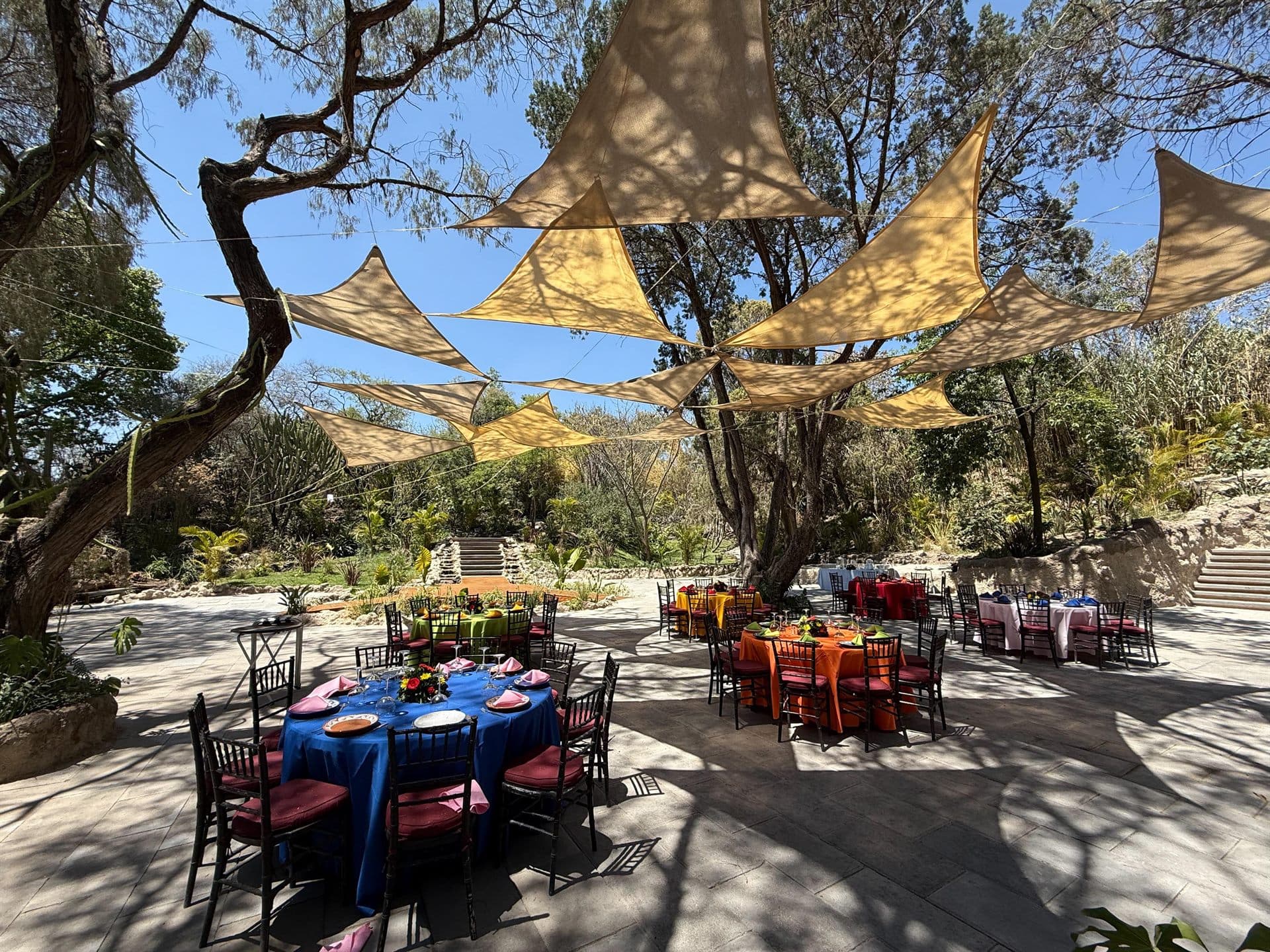 El montaje de banquete al aire libre, bajo velarias y entre los árboles