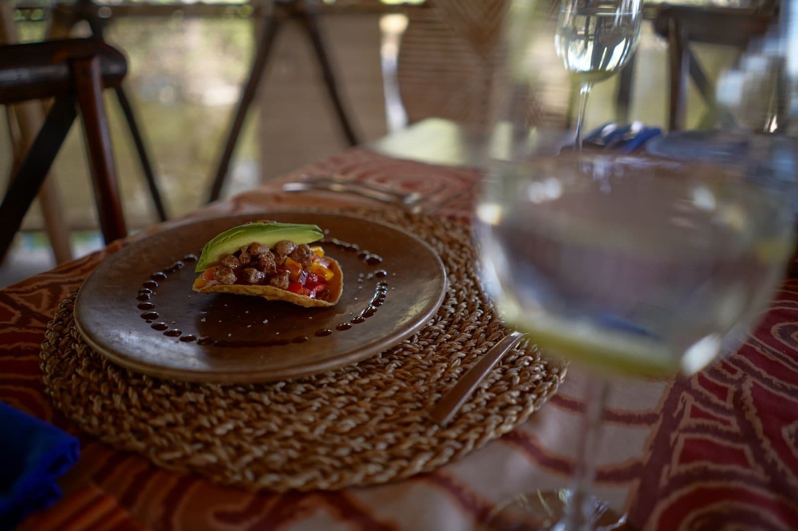 Tostada servida en plato de barro, sobre el tejido del mantel individual