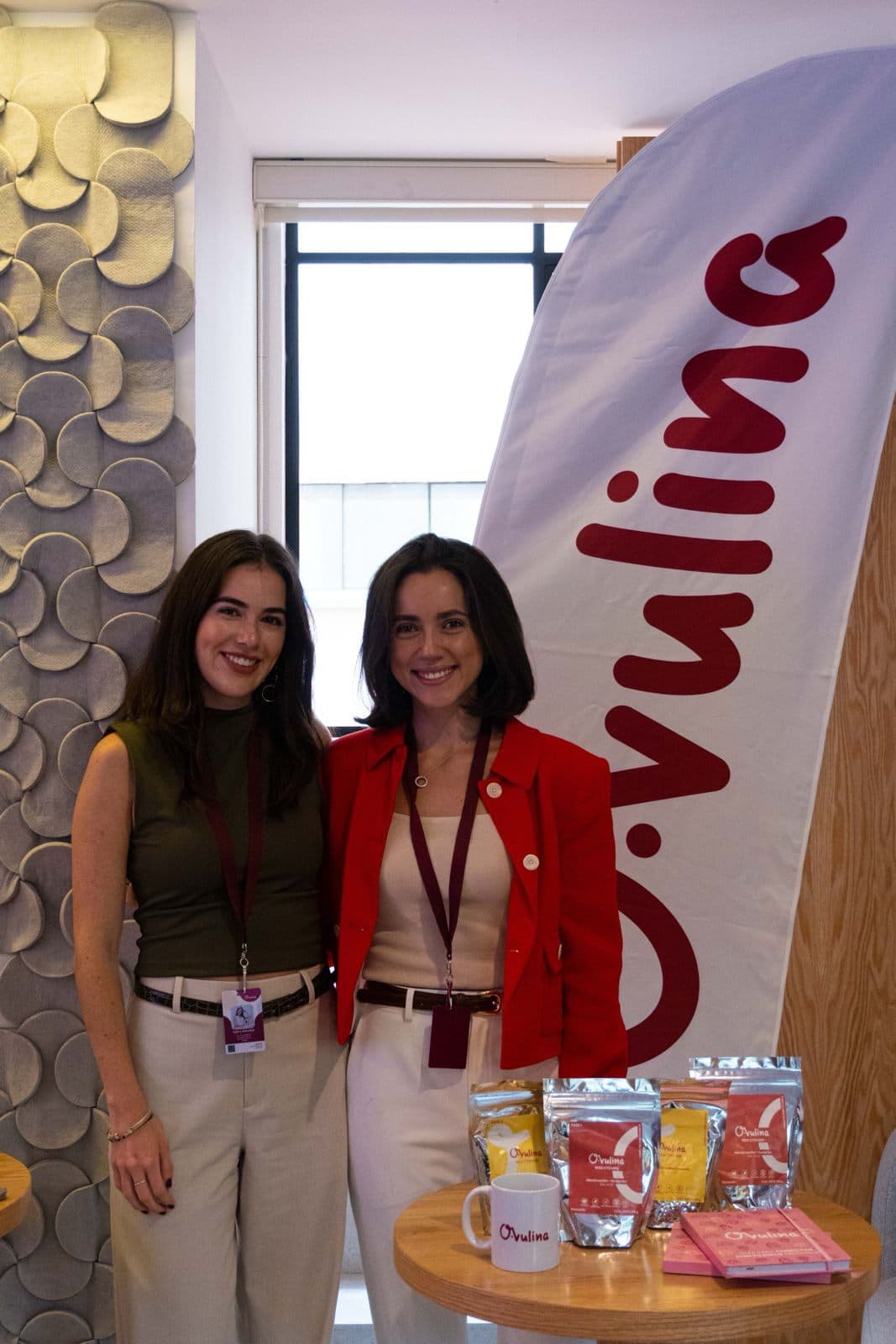 Las dos cofundadoras junto a su banner y sus productos