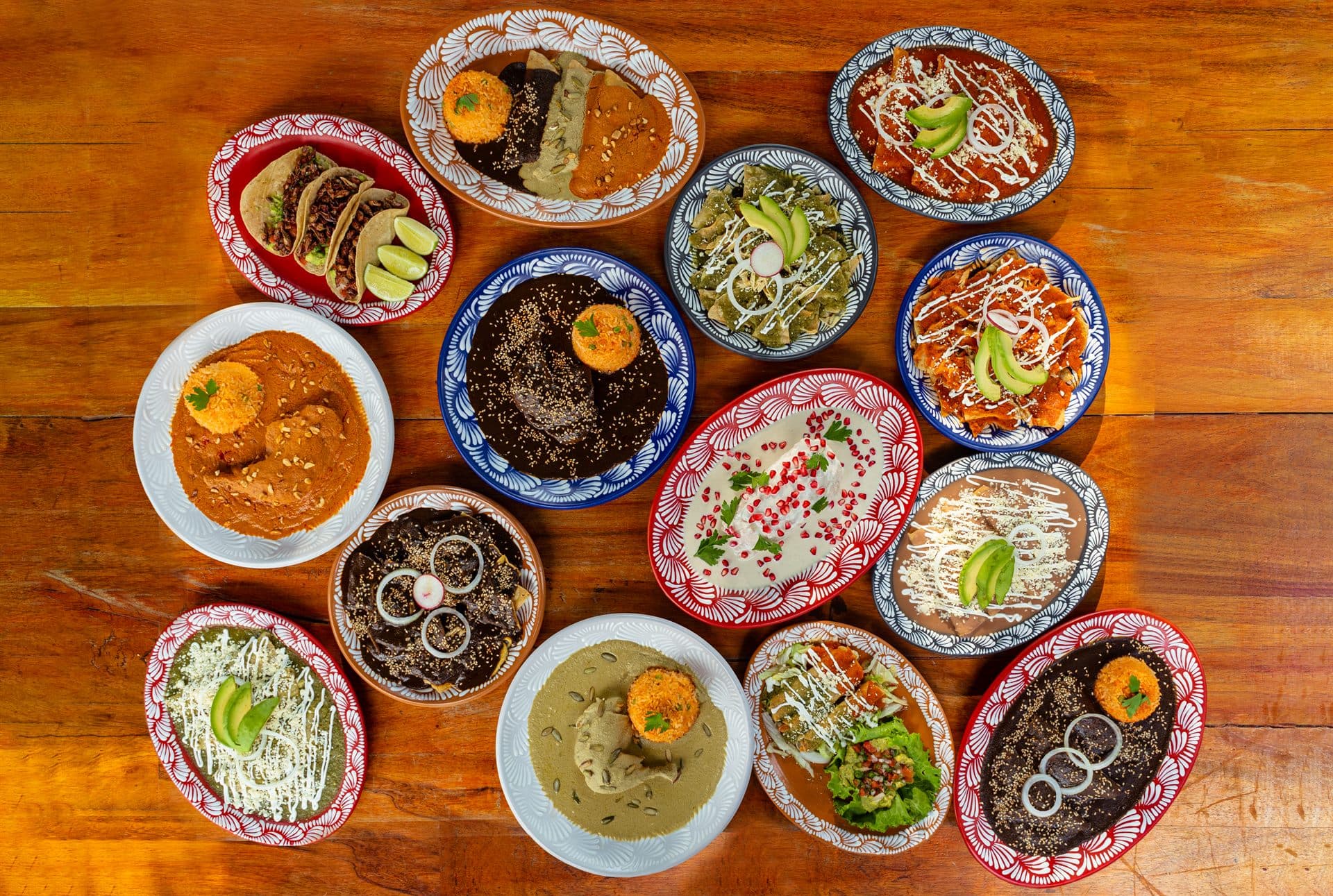 La mesa completa vista desde arriba: moles, chalupas, cecina y frijoles en talavera