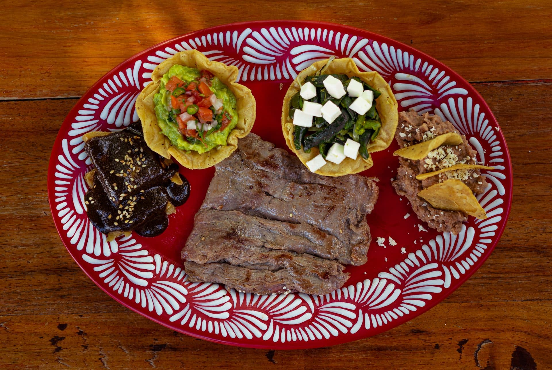 Plato de cecina con guacamole, nopales y mole, en talavera roja