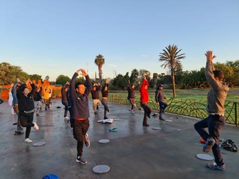 Estiramiento colectivo al amanecer, al aire libre